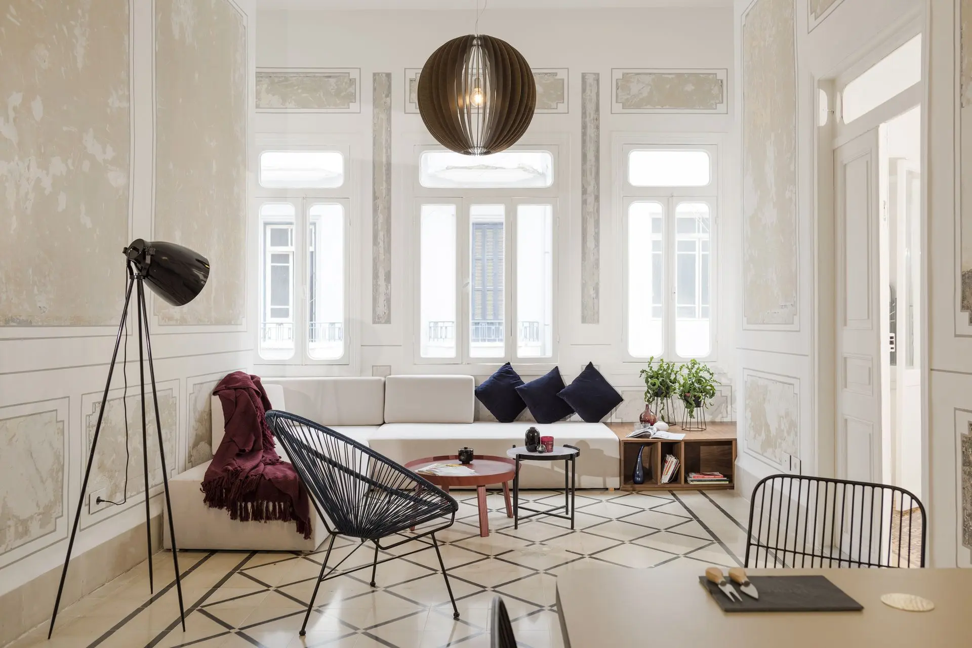 Luxurious white living room with classical molding, chandelier, and modern furniture
