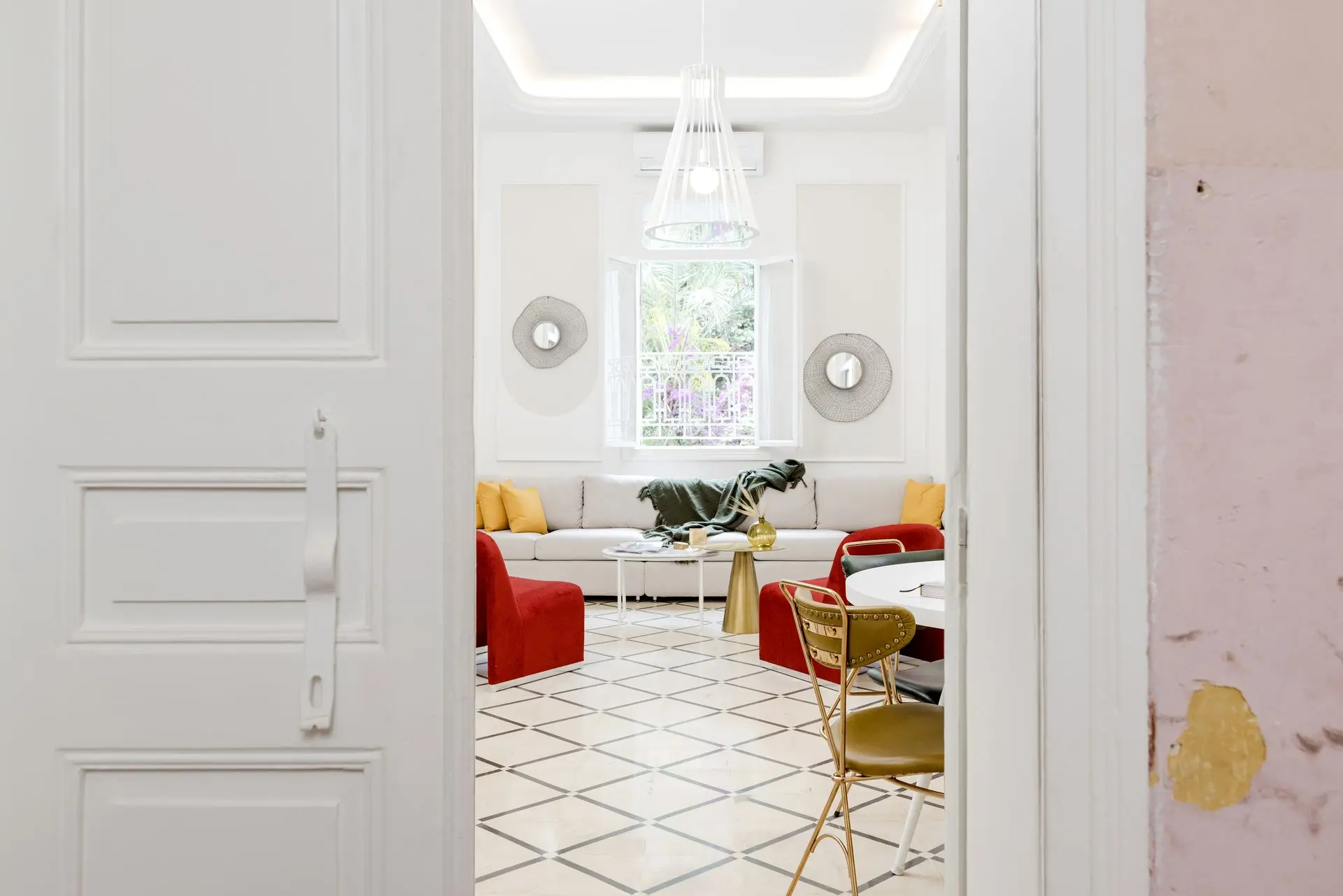 Elegant white hallway with mosaic tile flooring and arched doorway