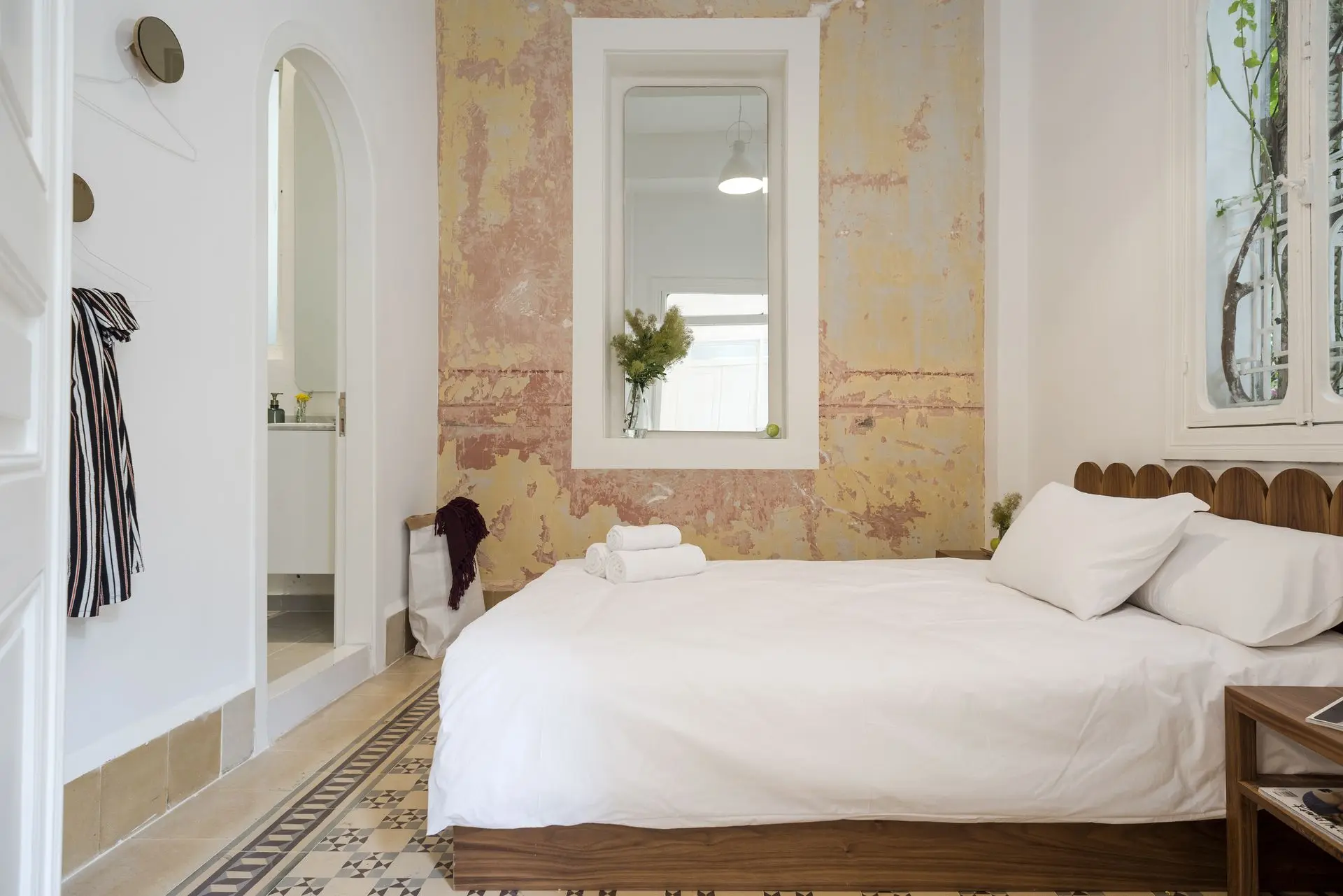 alt=&#34;Minimalist white bedroom with soft lighting and layered textiles&#34;
