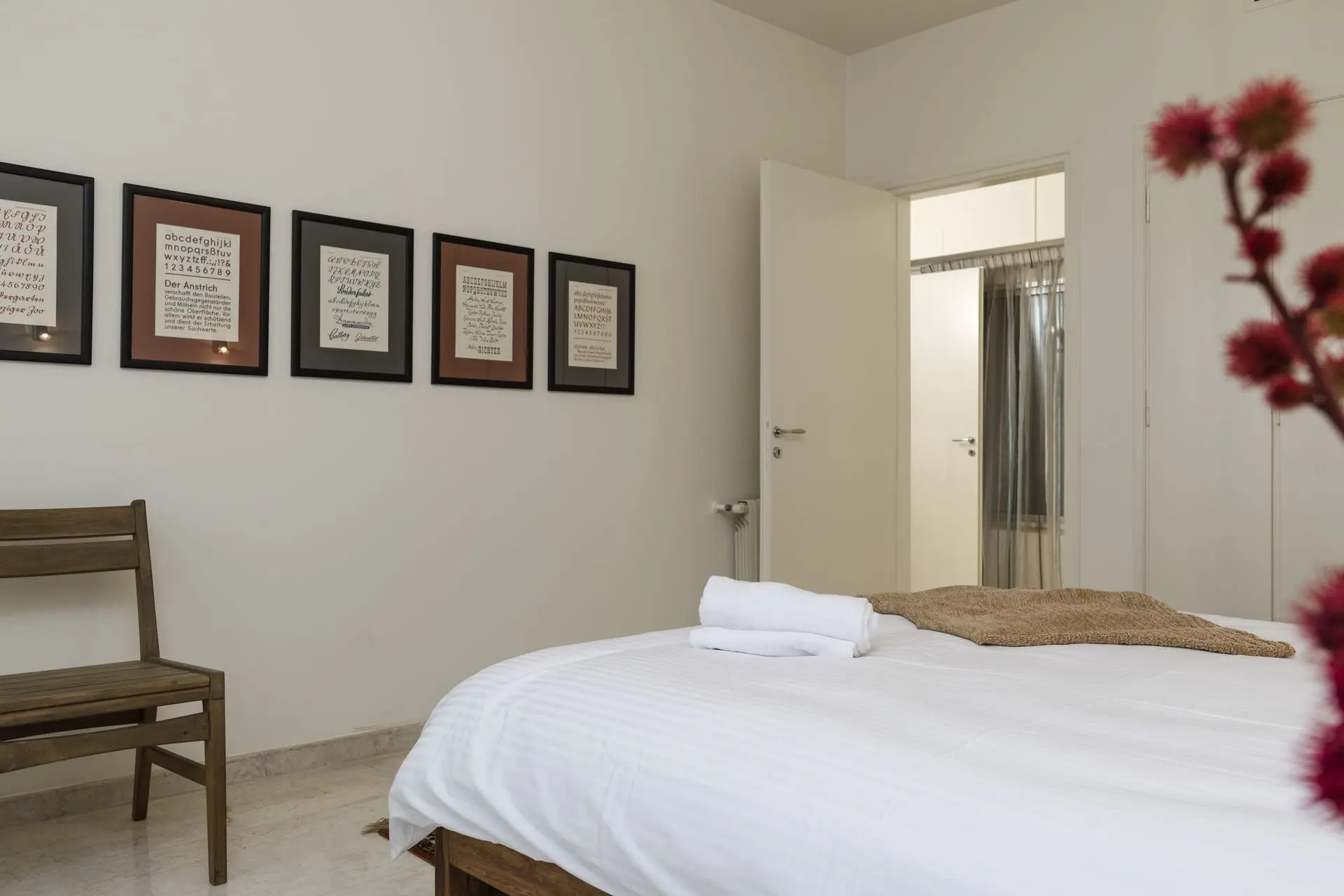 alt=&#34;Softly lit bedroom with flower arrangement and textured throw&#34;